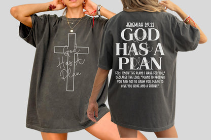 May include: Dark gray t-shirt with a white cross and the words "God Has A Plan" on the front. The back of the shirt features the text "Jeremiah 29:11" and the words "God Has A Plan".