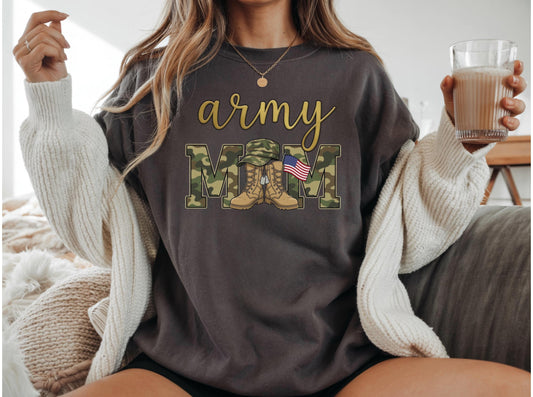 May include: Dark gray sweatshirt with the words "army mom" in gold script and camouflage block letters. The "M"s feature a military hat, boots, and an American flag. A cozy, off-white cardigan is draped over the shoulders.
