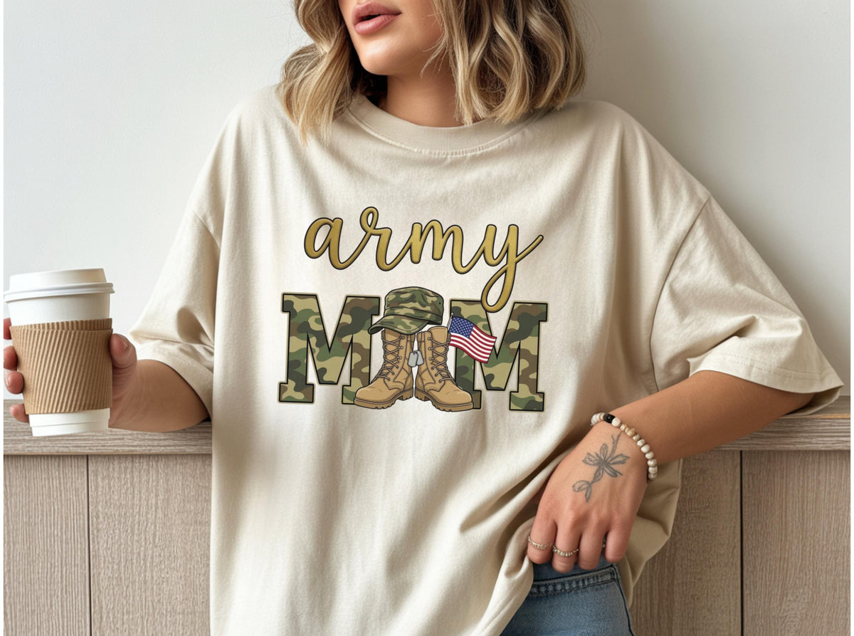 May include: Beige t-shirt with the words "army mom" in gold script. The word "MOM" is in camouflage print, with an illustration of combat boots, a military hat, and a small American flag.