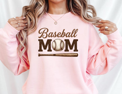 May include: A light pink sweatshirt with the words "Baseball MOM" in brown script and block letters. A baseball and bat graphic are below the text. The sweatshirt is a crew neck style.