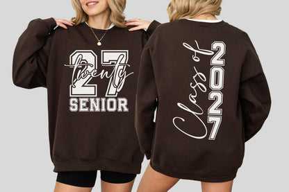 May include: A brown sweatshirt with white lettering. The front displays "27 Twenty SENIOR" in a collegiate style. The back features "Class of 2027" vertically. The sweatshirt has a white collar.