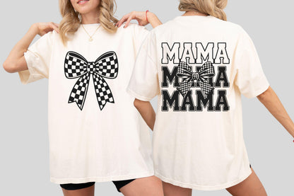 May include: Cream-colored t-shirt featuring a large black and white checkered bow on the front. The back of the shirt displays the word "MAMA" in a stacked design, also in black, with a checkered bow graphic.