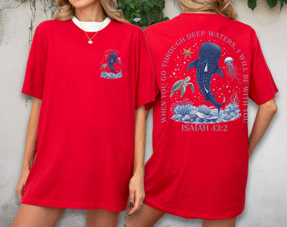 May include: Red t-shirt with a white collar featuring a graphic of a whale shark, turtle, and jellyfish. The back of the shirt has the text "When you go through deep waters, I will be with you" and "Isaiah 43:2".