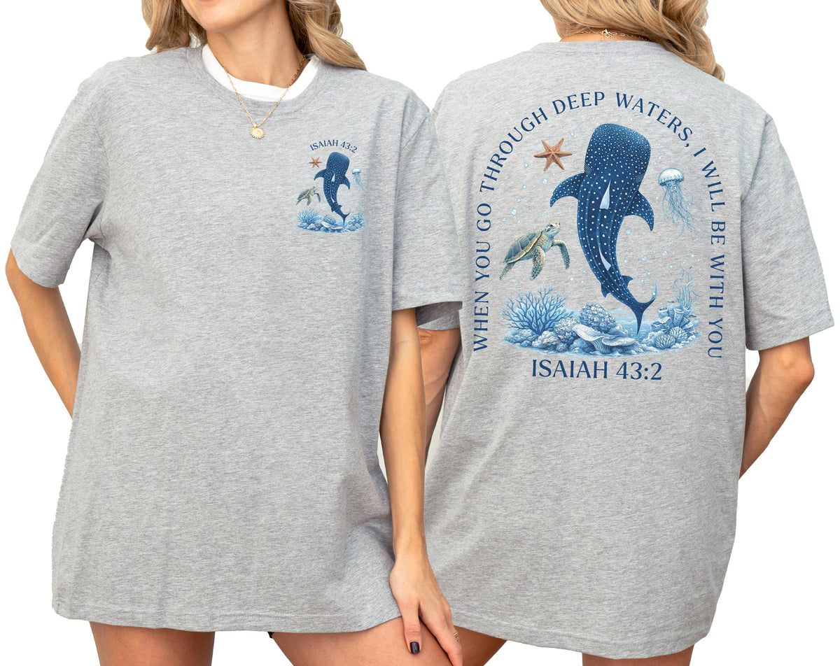 May include: A light gray t-shirt with a marine-themed design. The front features a whale shark illustration and the text "ISAIAH 43:2". The back has a larger design with a whale shark, jellyfish, and text: "WHEN YOU GO THROUGH DEEP WATERS, I WILL BE WITH YOU."