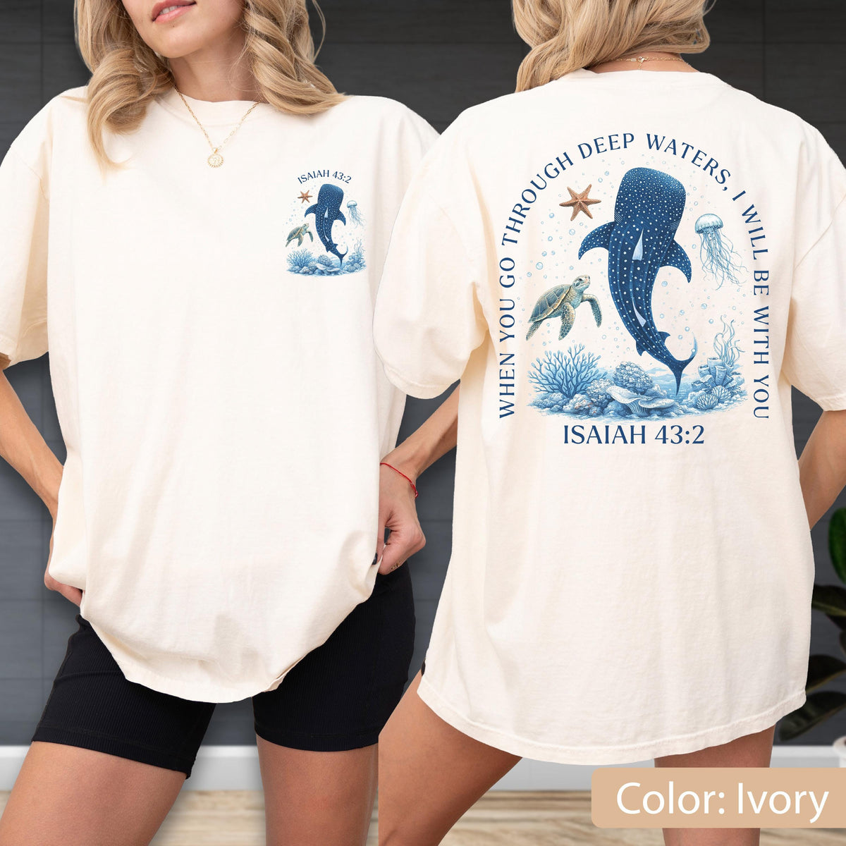 May include: Ivory-colored t-shirt featuring a blue whale and sea life graphic. The front has a small design with text "ISAIAH 43:2". The back displays a larger design with the text "WHEN YOU GO THROUGH DEEP WATERS, I WILL BE WITH YOU" and "ISAIAH 43:2".