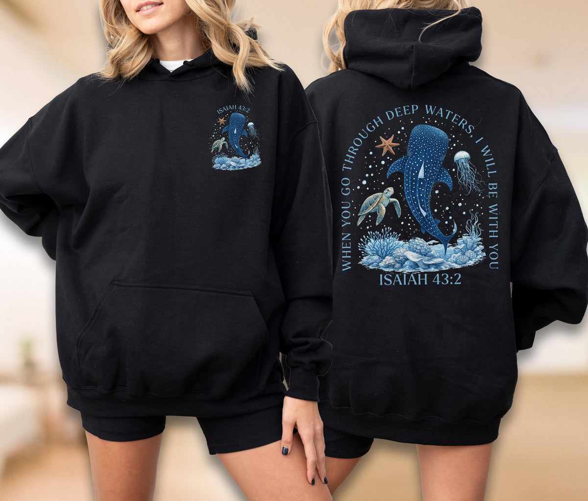 May include: Black hoodie with a front pocket and a hood. The front features a blue whale illustration with text "ISAIAH 43:2". The back displays a larger design with a whale, turtle, and jellyfish, and the text "WHEN YOU GO THROUGH DEEP WATERS, I WILL BE WITH YOU".