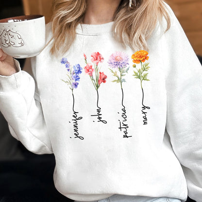 May include: White sweatshirt featuring four colorful floral designs with names Jennifer, John, Patricia, and Mary in a script font. Each flower is a different color, including blue, red, pink, and orange. The sweatshirt is a casual, personalized item.