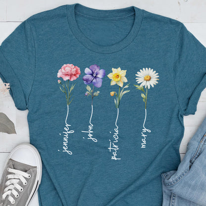 May include: Teal t-shirt featuring a floral design with four different flowers: a pink carnation, a purple pansy, a yellow daffodil, and a white daisy. Each flower has a name written below it in white script: Jennifer, John, Patricia, and Mary.