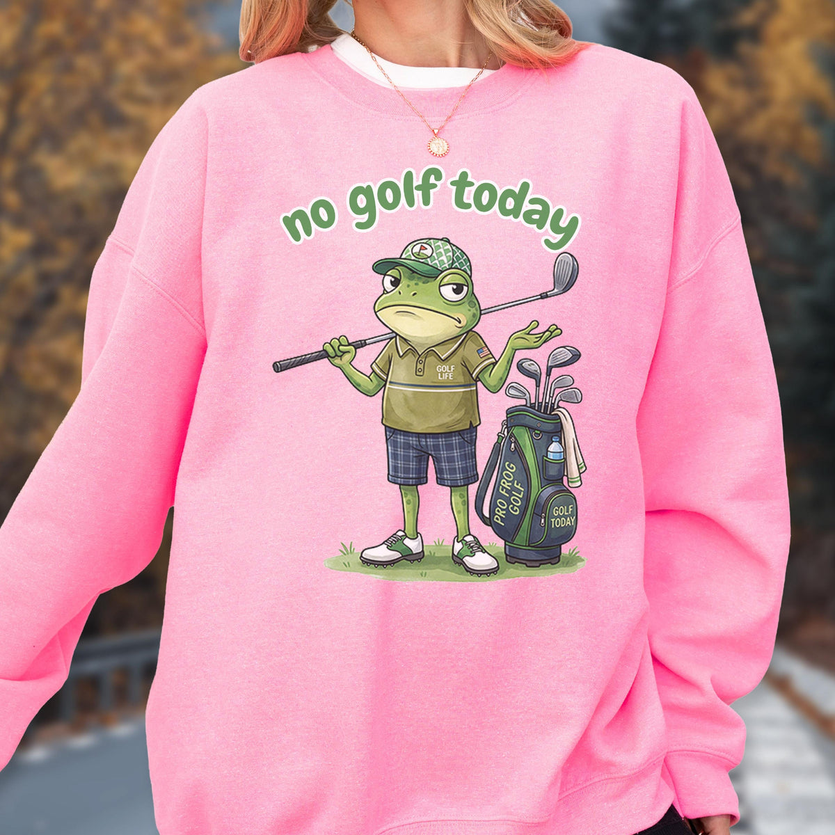 May include: Pink sweatshirt with the phrase "no golf today" in green. The graphic features a cartoon frog in a golf outfit, holding a golf club, with a golf bag beside it. The frog is wearing a golf hat and shorts.