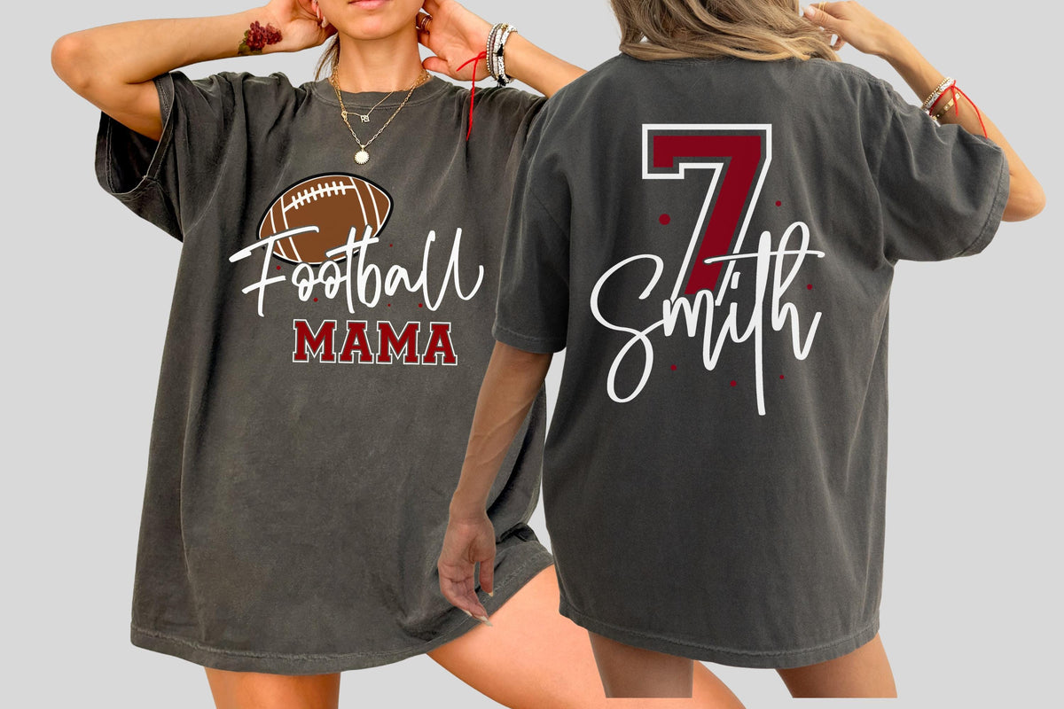May include: A charcoal gray t-shirt featuring a brown football graphic with the text Football MAMA in white and maroon on the front, and the number 7 in maroon with the name Smith in white script on the back, accented by small maroon dots.