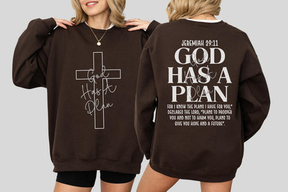 May include: A brown sweatshirt with the text "God Has A Plan" and a cross design on the front. The back of the sweatshirt features the text "Jeremiah 29:11 GOD HAS A PLAN" with a Bible verse.