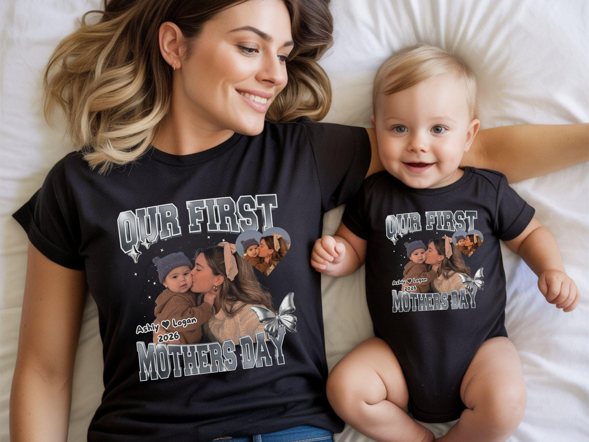 May include: Black t-shirt and baby onesie set with a photo print and text. The text reads "OUR FIRST MOTHERS DAY" with a photo of a mother and child. The set is a matching outfit for Mother's Day.