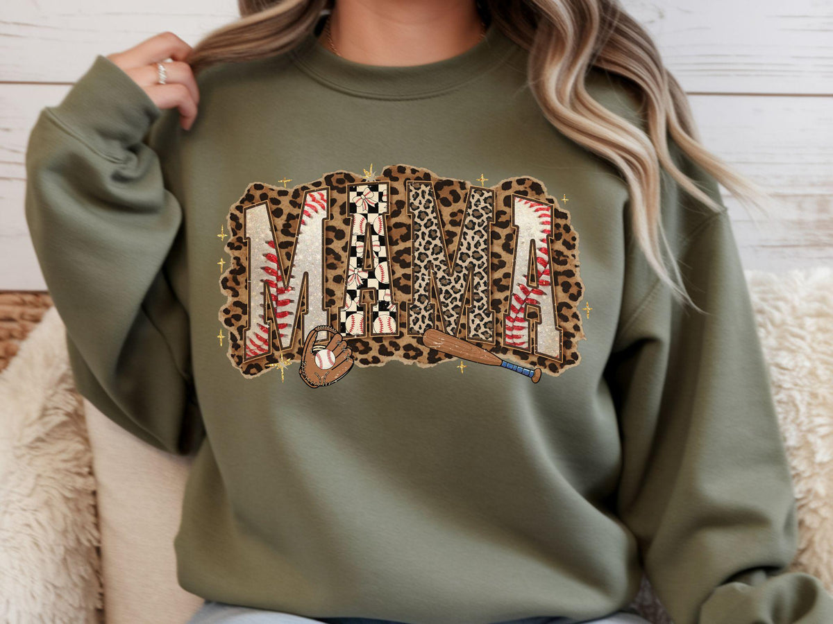 May include: Olive green sweatshirt with the word "MAMA" in a baseball-themed design. The letters feature a mix of leopard print, baseball stitching, and a checkered pattern. A baseball and bat are also included.