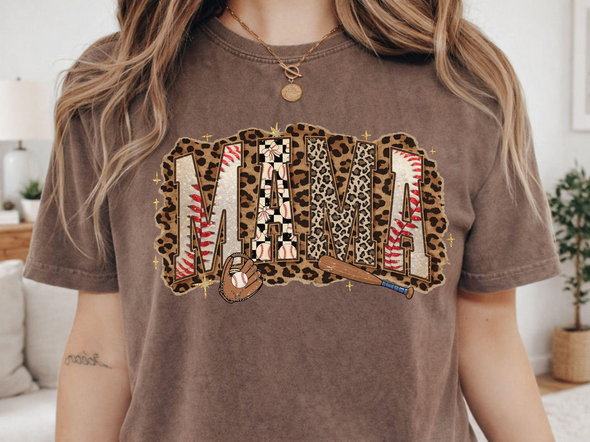 May include: Brown t-shirt with the word "MAMA" in a baseball-themed design. The letters are a mix of leopard print, baseball stitching, and a checkered pattern. A baseball bat and glove are featured below the word.