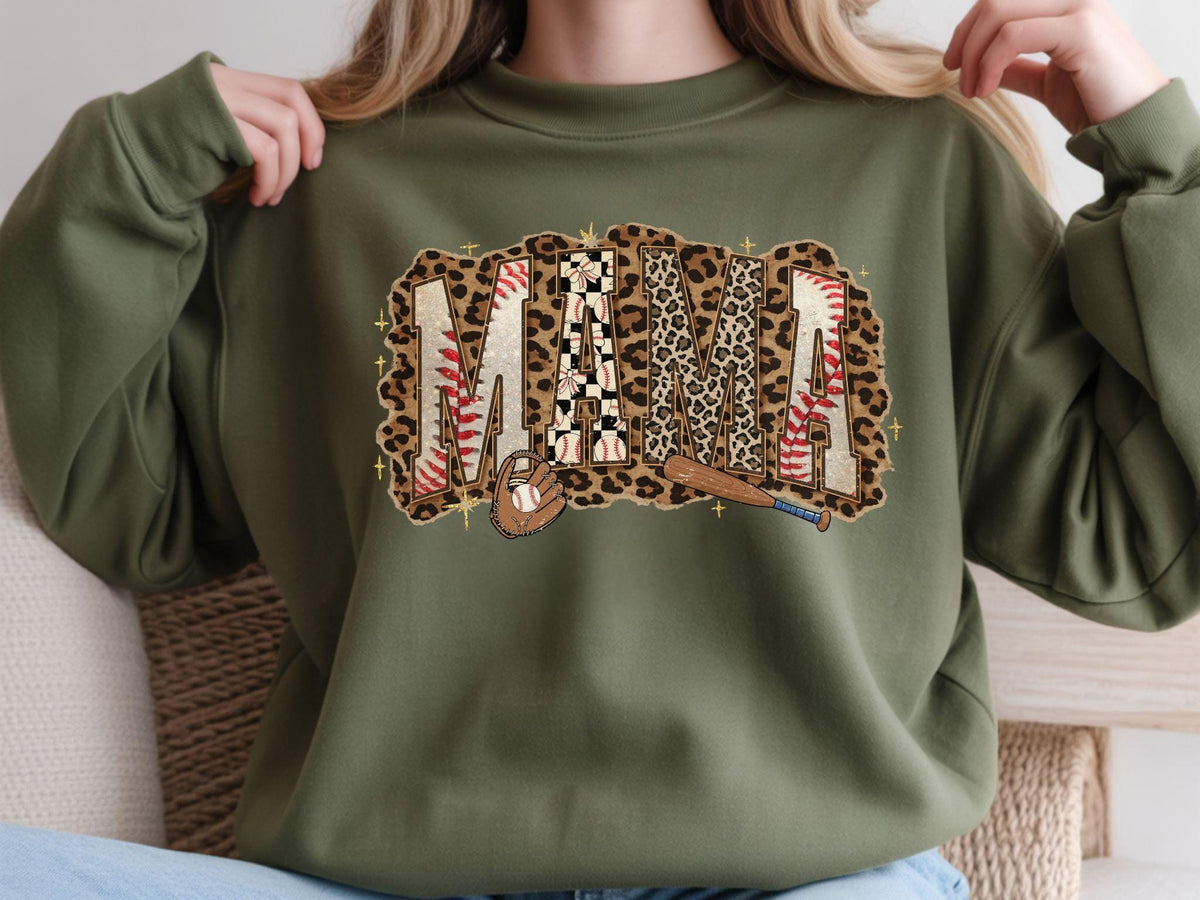 May include: Olive green sweatshirt with a baseball-themed "MAMA" graphic. The graphic features the word "MAMA" in a mix of leopard print, baseball stitching, and checkered patterns, with baseball and bat illustrations.