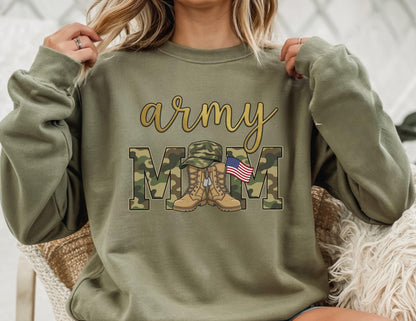 May include: Olive green sweatshirt with the words "army mom" in gold script and camouflage block letters. The design includes a military hat, boots, and an American flag.