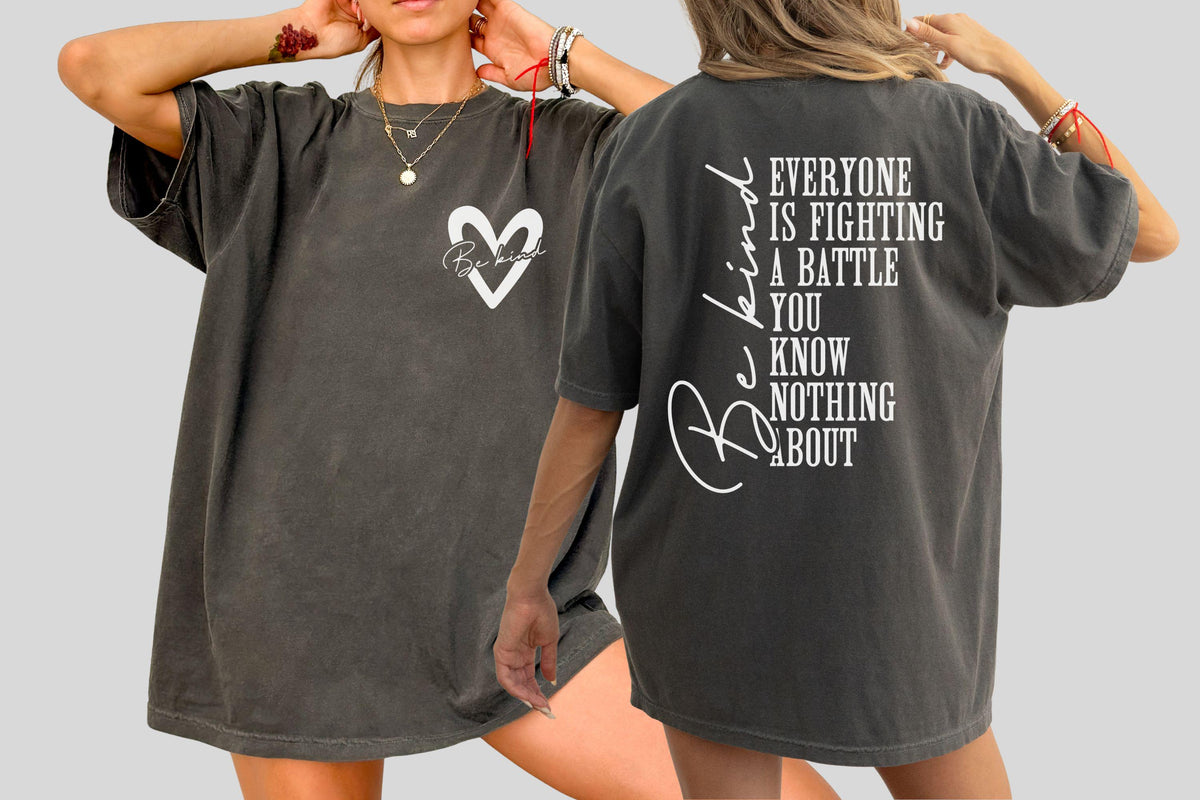 May include: Dark gray oversized t-shirt with a white heart graphic and the words "Be kind" on the front. The back of the shirt features the text "Everyone is fighting a battle you know nothing about."