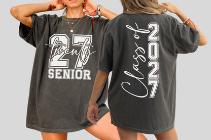 May include: Dark gray oversized t-shirt with white text. The front features "27 Twenty Senior" in a collegiate font. The back displays "Class of 2027" vertically. A casual, comfortable garment for graduation.