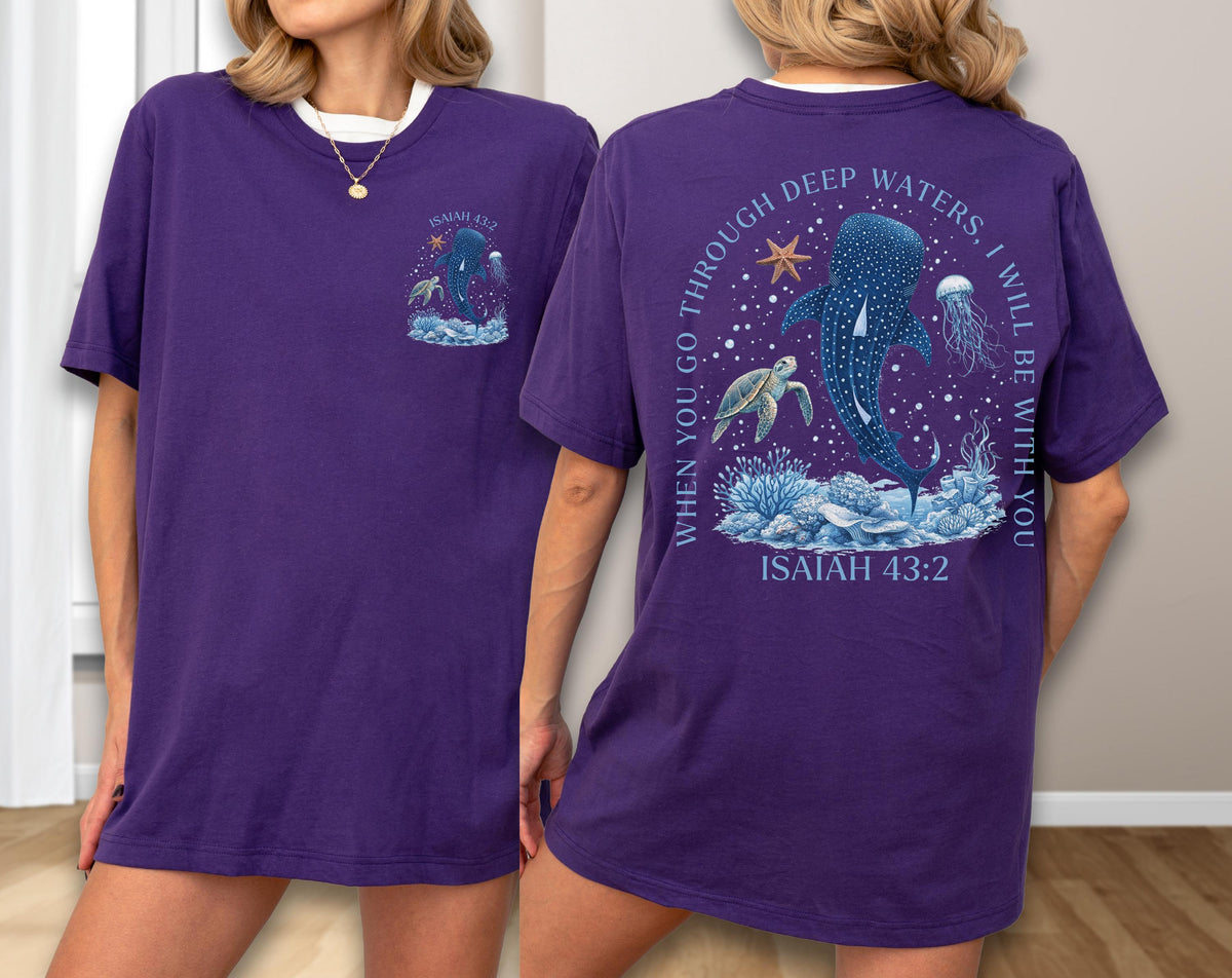 May include: Purple t-shirt with a white collar featuring a marine-themed graphic. The front has a small design with a whale shark, turtle, and jellyfish. The back displays a larger design with the text "WHEN YOU GO THROUGH DEEP WATERS, I WILL BE WITH YOU" and "ISAIAH 43:2".