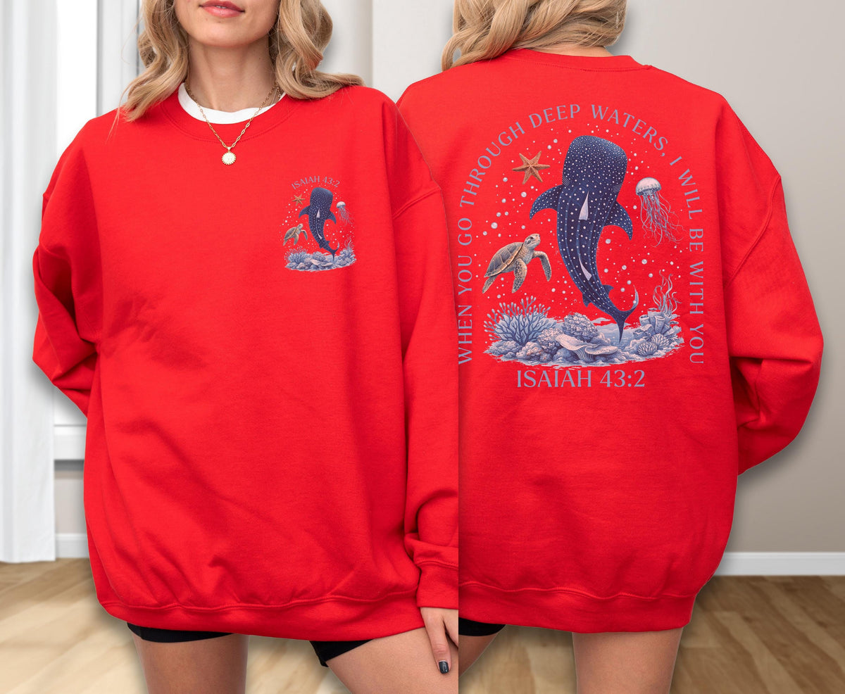 May include: Red sweatshirt with a marine-themed graphic. The front features a whale shark design, while the back displays a larger illustration with a whale shark, turtle, and jellyfish, along with the text "WHEN YOU GO THROUGH DEEP WATERS, I WILL BE WITH YOU" and "ISAIAH 43:2".