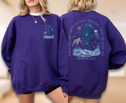May include: A purple sweatshirt featuring a marine life design with a whale shark, turtle, and jellyfish. The front has a smaller graphic, while the back displays the text "WHEN YOU GO THROUGH DEEP WATERS, I WILL BE WITH YOU" and "ISAIAH 43:2."