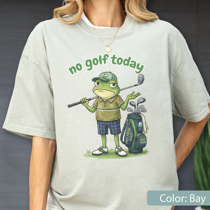 May include: Bay-colored t-shirt featuring a cartoon frog golfer with the text "no golf today." The frog is wearing a golf cap and holding a golf club. A golf bag with the text "Pro Frog Golf" is also visible.