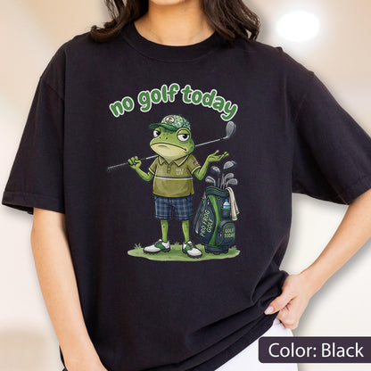 May include: Black t-shirt featuring a cartoon frog golfer with the text "no golf today". The frog is wearing a golf hat, polo shirt, and plaid shorts, holding a golf club. A golf bag with clubs is next to the frog.