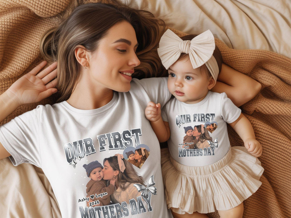 May include: White t-shirts with a photo print and the text "OUR FIRST MOTHERS DAY". The shirts have a photo of a mother and child. The baby is wearing a beige skirt and headband.