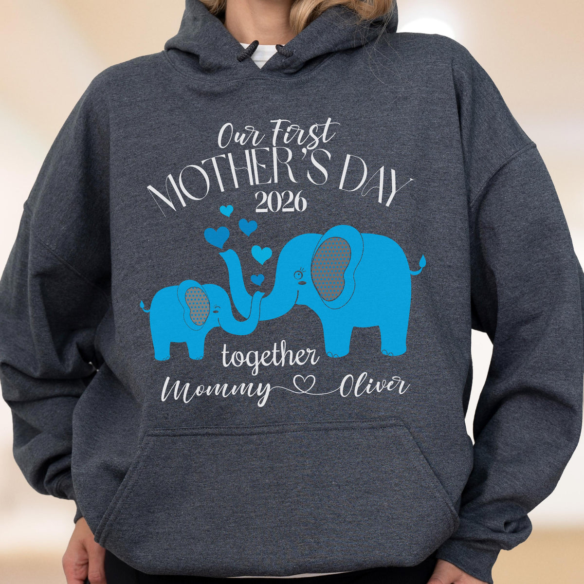 May include: Dark gray hoodie with a blue elephant graphic and the text "Our First Mother's Day 2026" above two blue elephants. Below the elephants is the text "together Mommy Oliver".