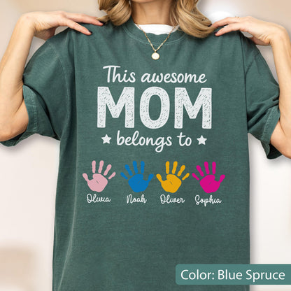May include: Blue spruce t-shirt with the text "This awesome MOM belongs to" and four colorful handprints. Below the handprints are the names Olivia, Noah, Oliver, and Sophia. The shirt is a solid color.