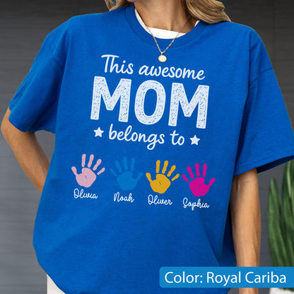 May include: Royal blue t-shirt with the text "This awesome MOM belongs to" and four colorful handprints. The names Olivia, Noah, Oliver, and Sophia are printed below the handprints. The shirt's color is Royal Cariba.