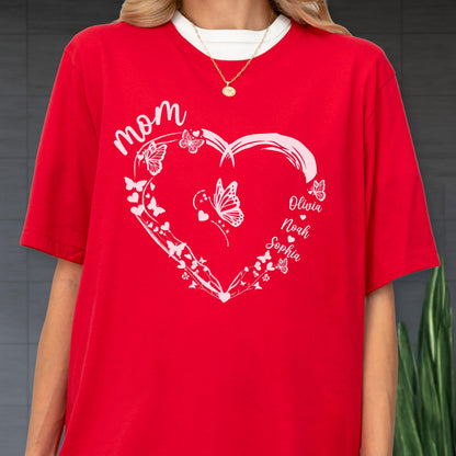 May include: Red t-shirt with a white heart-shaped design filled with butterflies and the word "Mom". The names Olivia, Noah, and Sophia are printed on the right side of the heart. The shirt has a white collar.
