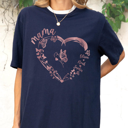 May include: Navy blue t-shirt with a white collar featuring a rose gold heart design filled with butterflies. The word "mama" is written above the heart, and the names "Olivia", "Noah", and "Sophia" are inside the heart.