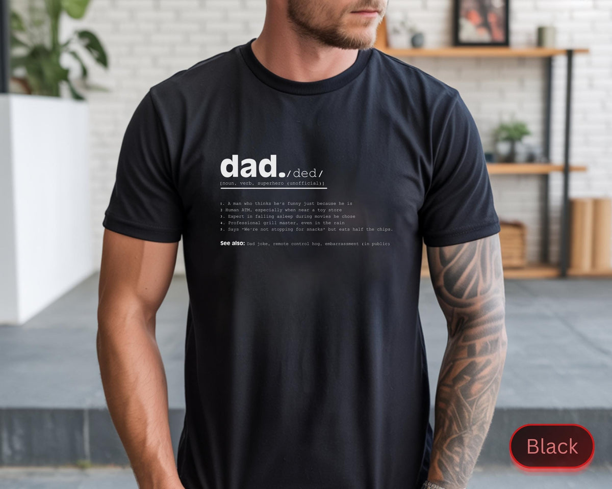 May include: Black t-shirt with the definition of "dad" printed in white. The definition includes a list of humorous characteristics. The shirt is a crew neck and appears to be made of a soft material.