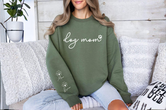 May include: Olive green sweatshirt with the words "dog mom" in white script, a paw print, and two paw prints with the names "Max" and "Luna" below. The sweatshirt is a casual style.