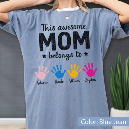 May include: Blue jean colored t-shirt with the text "This awesome MOM belongs to" and four colorful handprints. Each handprint has a name below it: Olivia, Noah, Oliver, and Sophia.