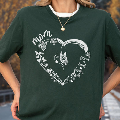 May include: Dark green t-shirt with a white heart-shaped design. The word "mom" is at the top, with butterflies and the names Olivia, Noah, and Sophia inside the heart. The shirt has a white crew neck.