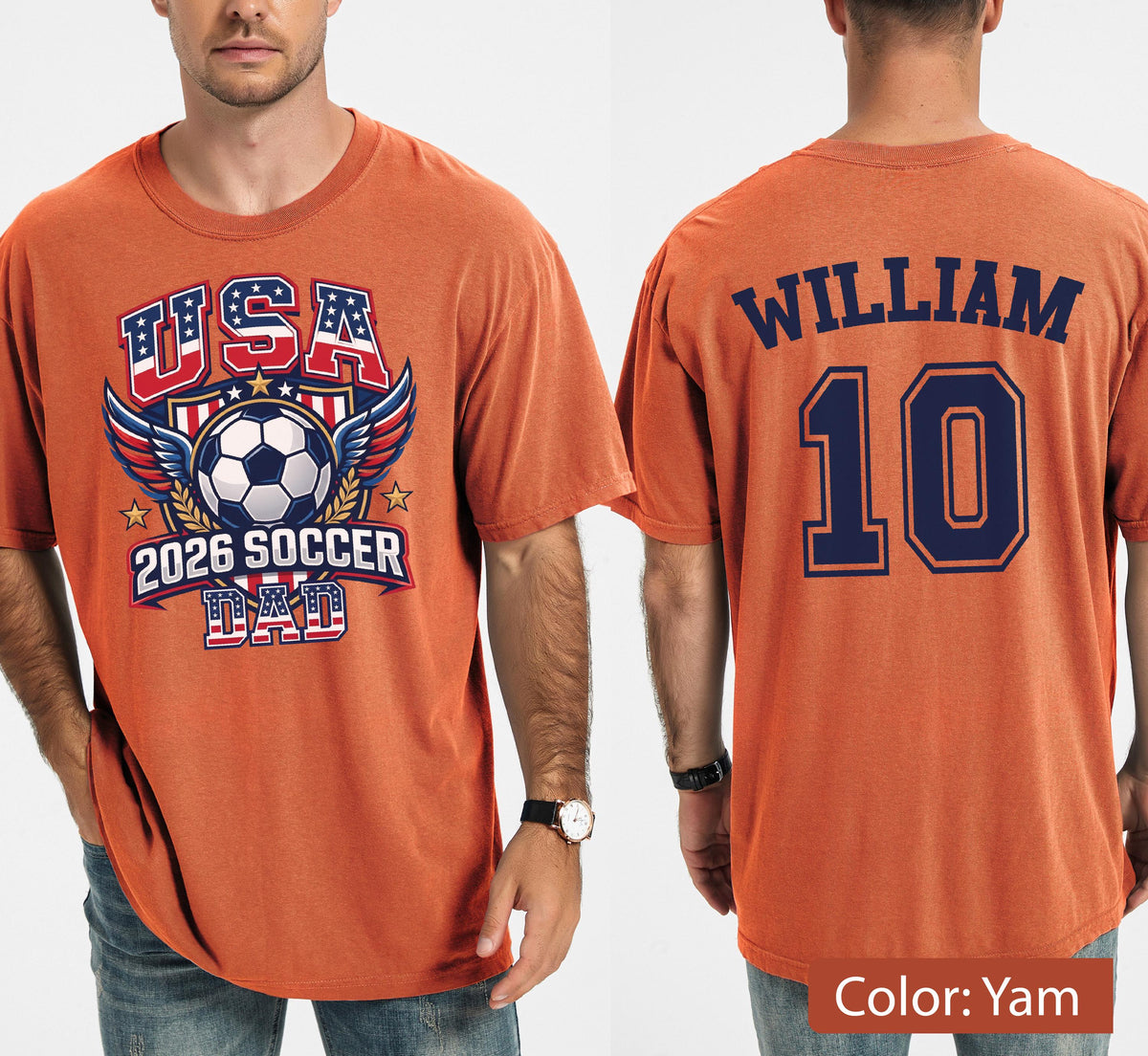 May include: Orange t-shirt with a soccer-themed graphic. The front features "USA" in red and blue, a soccer ball, wings, and "2026 SOCCER DAD." The back displays "WILLIAM" and the number "10" in navy blue.