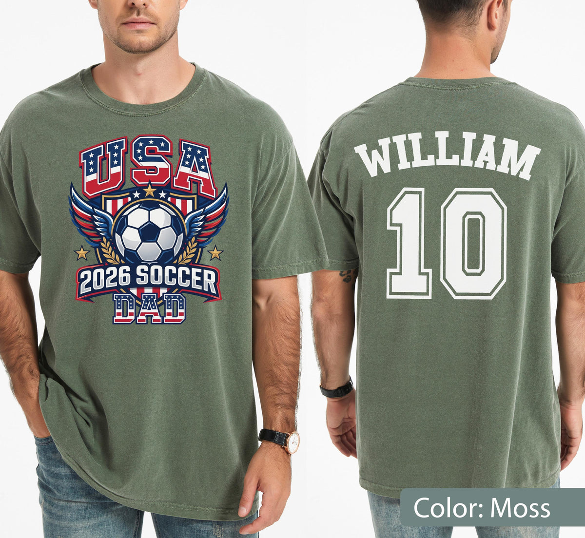 May include: Moss green t-shirt with "USA 2026 SOCCER DAD" graphic on the front, featuring a soccer ball, wings, and stars. The back displays "WILLIAM 10" in white block letters. The shirt is a casual, short-sleeved style.