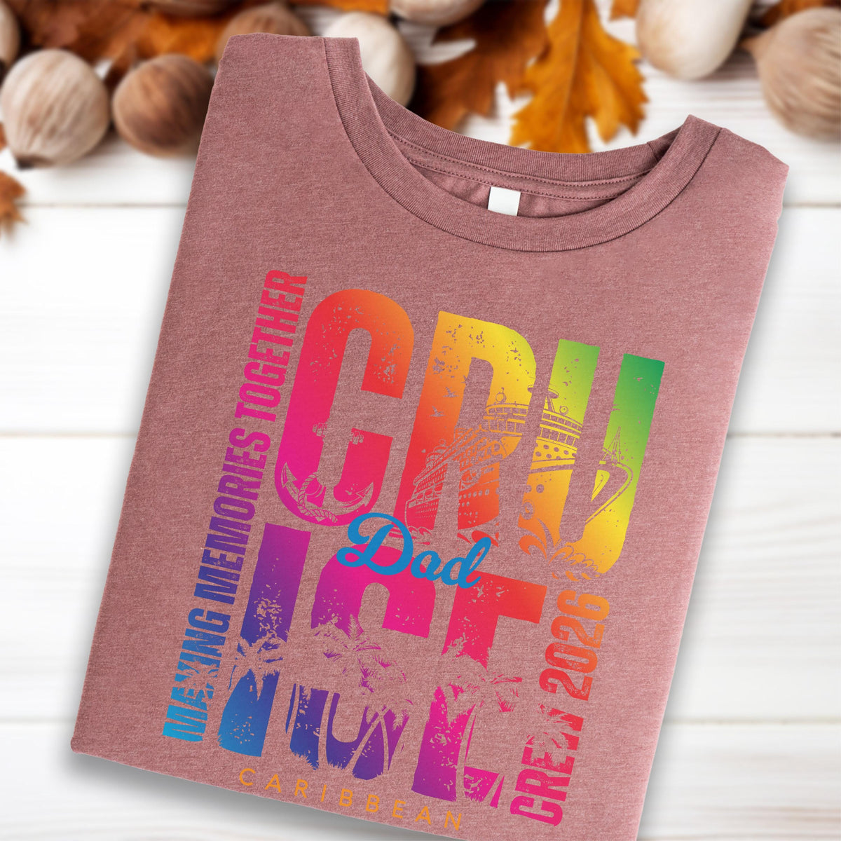 May include: A mauve-colored t-shirt with a colorful graphic that reads "CRUISE CREW 2020" in rainbow hues. The design includes an anchor, cruise ship, palm trees, and the word "Dad" in light blue. The text "MAKING MEMORIES TOGETHER" and "CARIBBEAN" are also visible.