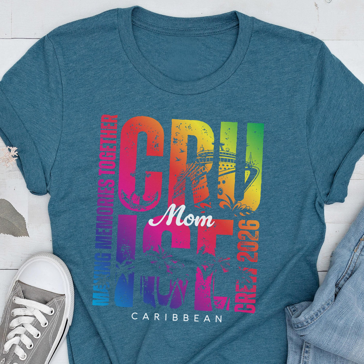 May include: Teal t-shirt with a colorful graphic that says "CRUISE Mom CARIBBEAN 2026". The word "CRUISE" is in large, rainbow-colored letters, with a cruise ship illustration. The text "MAKING MEMORIES TOGETHER" is printed vertically on the left side.