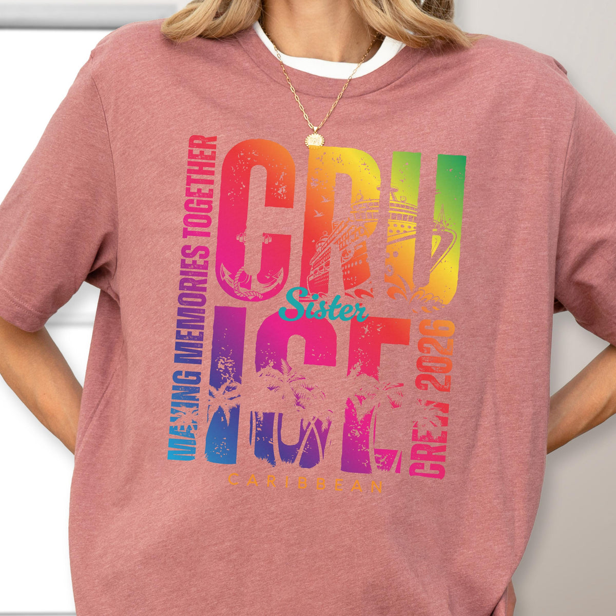 May include: A short-sleeved, dusty rose t-shirt with a colorful graphic. The graphic reads "CRUISE" in large, rainbow-colored letters, with "Sister" in teal. Additional text includes "MAKING MEMORIES TOGETHER", "CREW 2020", and "CARIBBEAN".