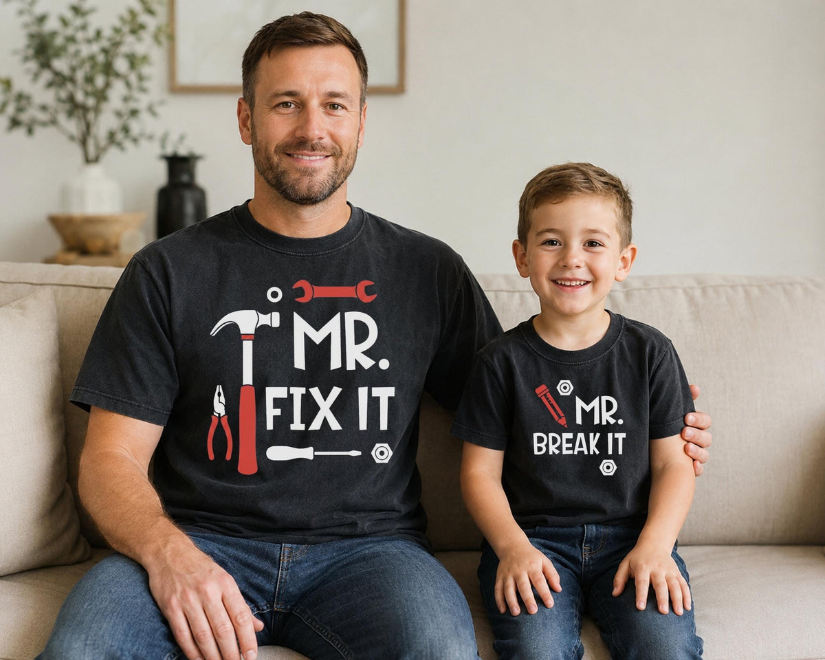 May include: Two black short-sleeved t-shirts. The larger shirt features a red hammer, wrench, pliers, screwdriver, and the white text 'MR. FIX IT'. The smaller shirt features a red pencil and the white text 'MR. BREAK IT' with small white nut icons.