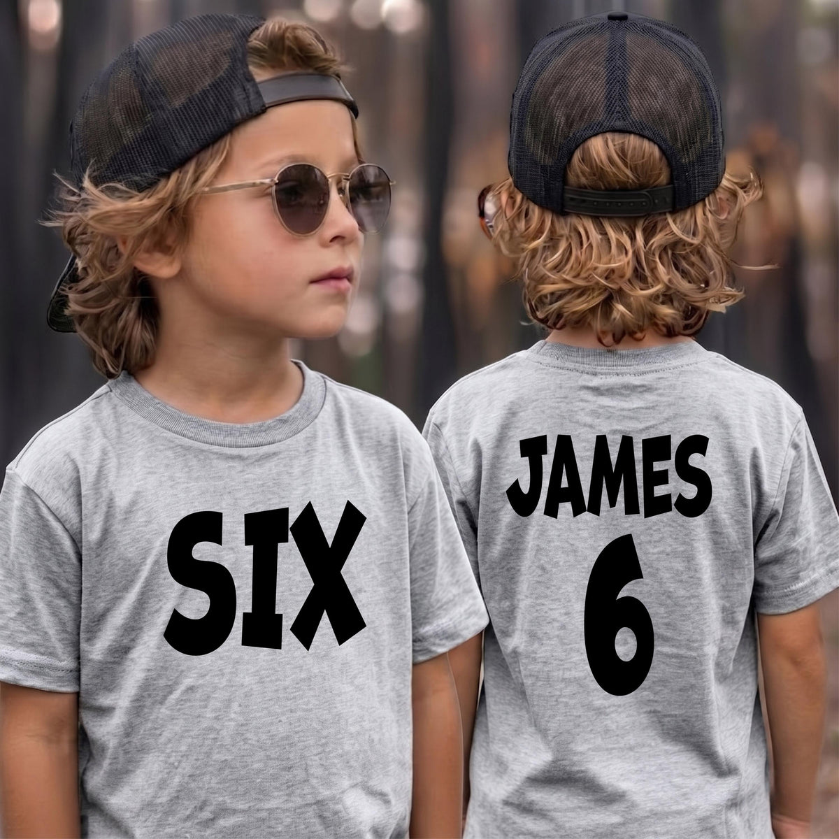 May include: A grey t-shirt featuring the word SIX in black lettering on the front and the name JAMES with the number 6 in black lettering on the back. The shirt is paired with a black mesh trucker hat and round-frame sunglasses.