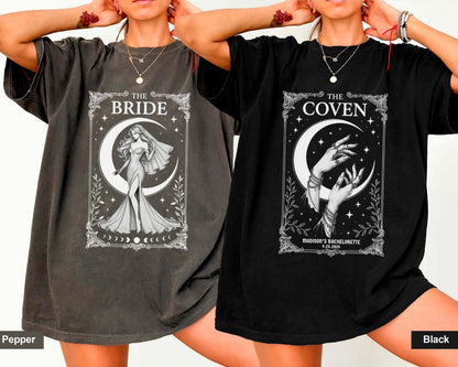 May include: Two short-sleeve t-shirts in pepper and black colors. The pepper shirt features a white graphic of a bride under a crescent moon with the text THE BRIDE. The black shirt shows hands under a crescent moon with THE COVEN and text.