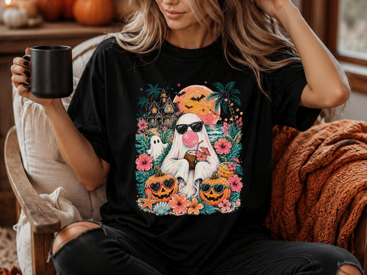 May include: A black t-shirt featuring a colorful graphic print of a ghost wearing sunglasses and blowing a pink bubble, surrounded by tropical flowers, palm trees, a haunted house, a large orange moon with bats, and two jack-o'-lanterns.
