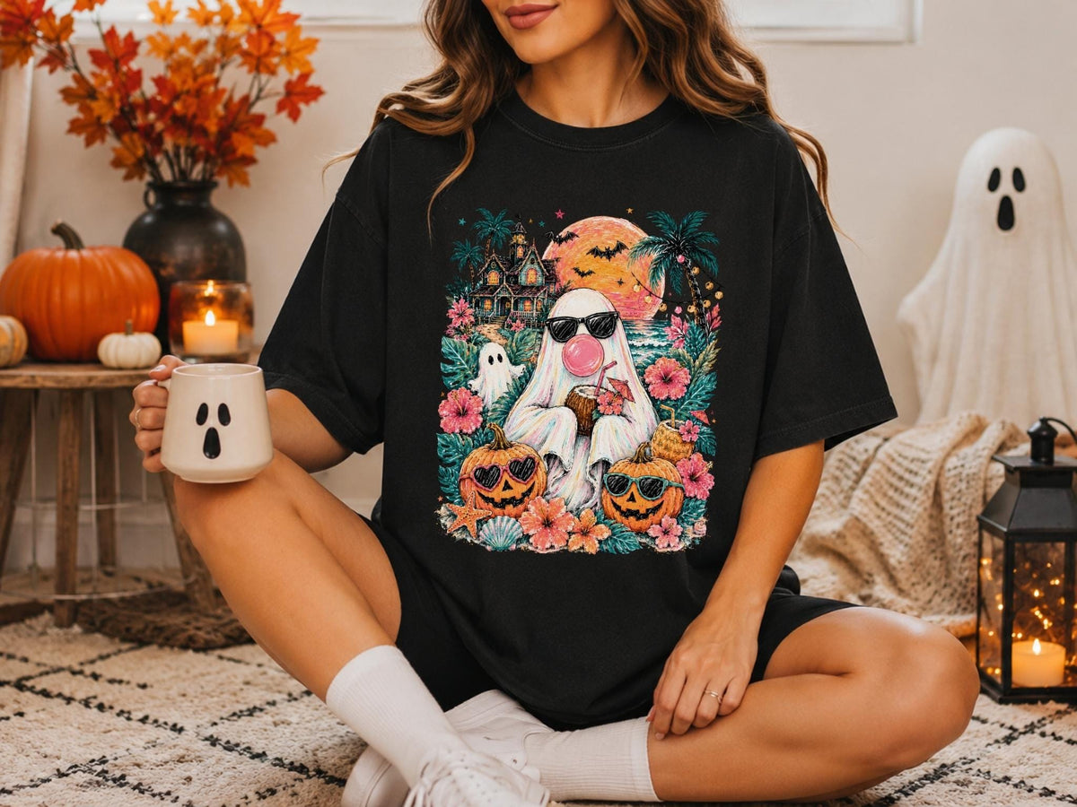 May include: A black t-shirt featuring a colorful graphic print of a ghost wearing sunglasses and blowing a bubblegum bubble, surrounded by tropical flowers, palm trees, a haunted house, bats, a full moon, and two jack-o'-lanterns with sunglasses.