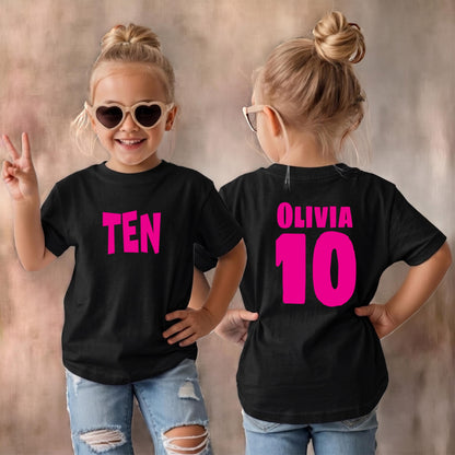 May include: A black short-sleeved t-shirt featuring the word TEN in bright pink lettering on the front and the name OLIVIA above the number 10 in bright pink lettering on the back, paired with light blue distressed denim jeans and sunglasses.