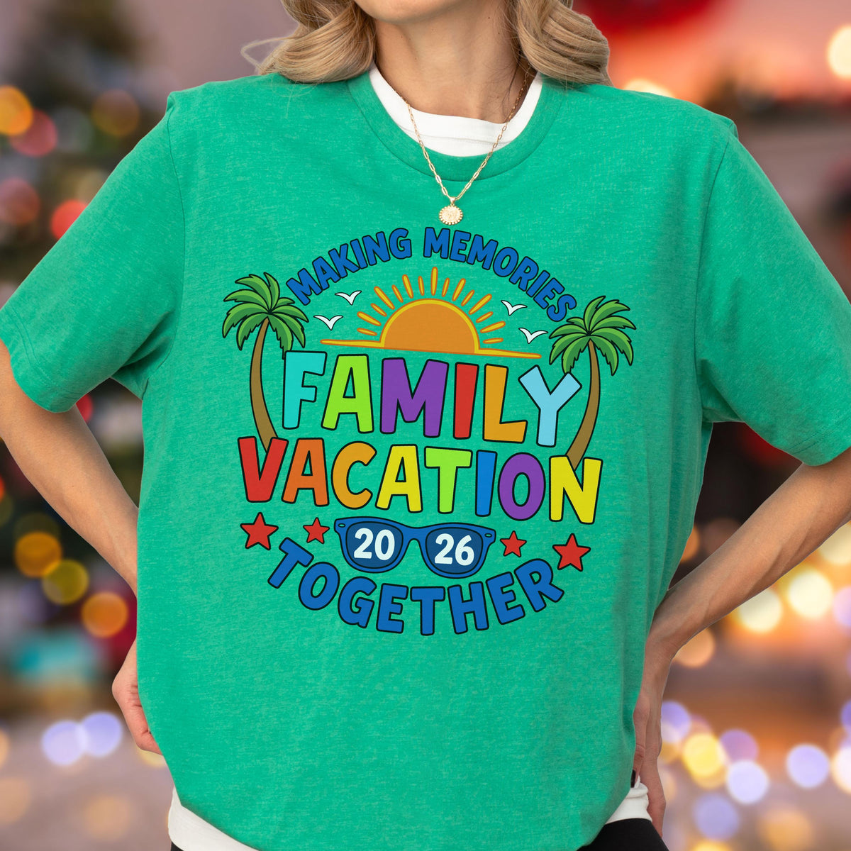 May include: A bright green short-sleeved t-shirt featuring a colorful graphic print. The design includes palm trees, a sun, and the text "MAKING MEMORIES FAMILY VACATION TOGETHER 20 26" with a pair of blue sunglasses integrated into the year.