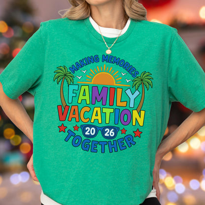 May include: A bright green short-sleeved t-shirt featuring a colorful graphic print. The design includes palm trees, a sun, and the text "MAKING MEMORIES FAMILY VACATION TOGETHER 20 26" with a pair of blue sunglasses integrated into the year.